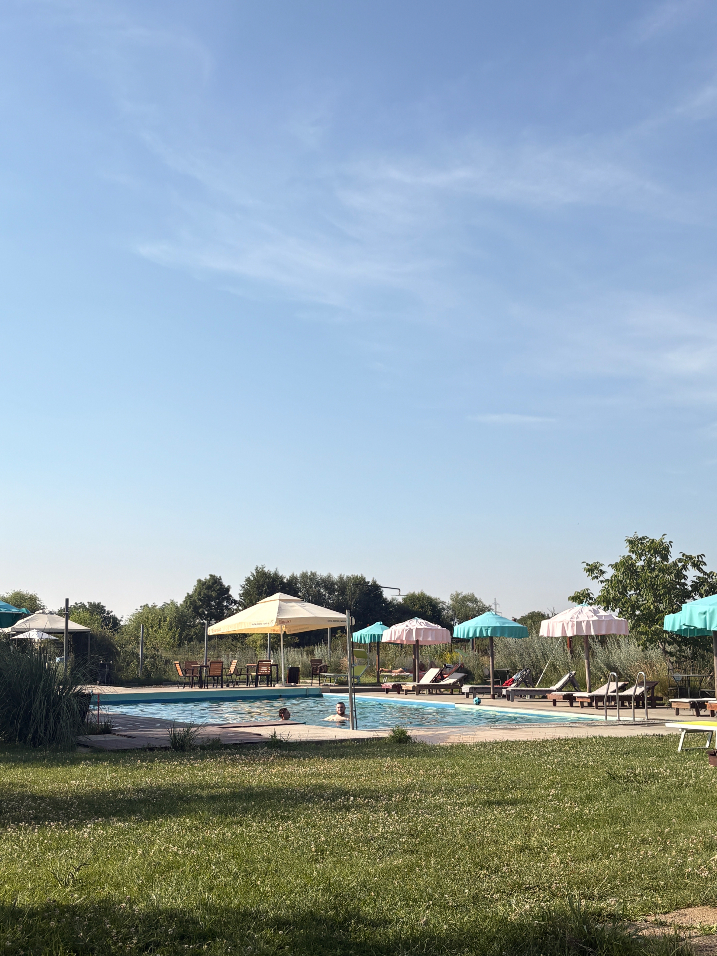 Piscina de la Terasa ATC cu șezlonguri și umbrelă de soare